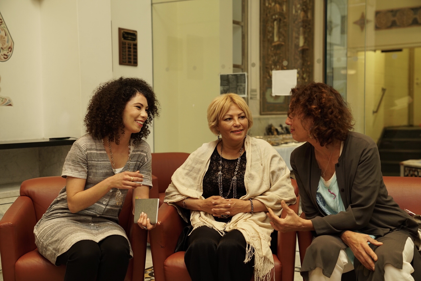 Three woman sit and talk together